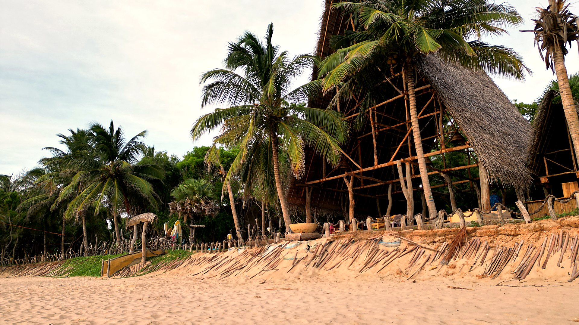 Bamboo A-frame restaurant framing the sea