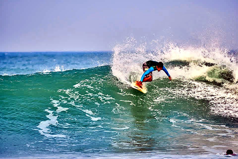 Surfer carving a turn and throwing spray