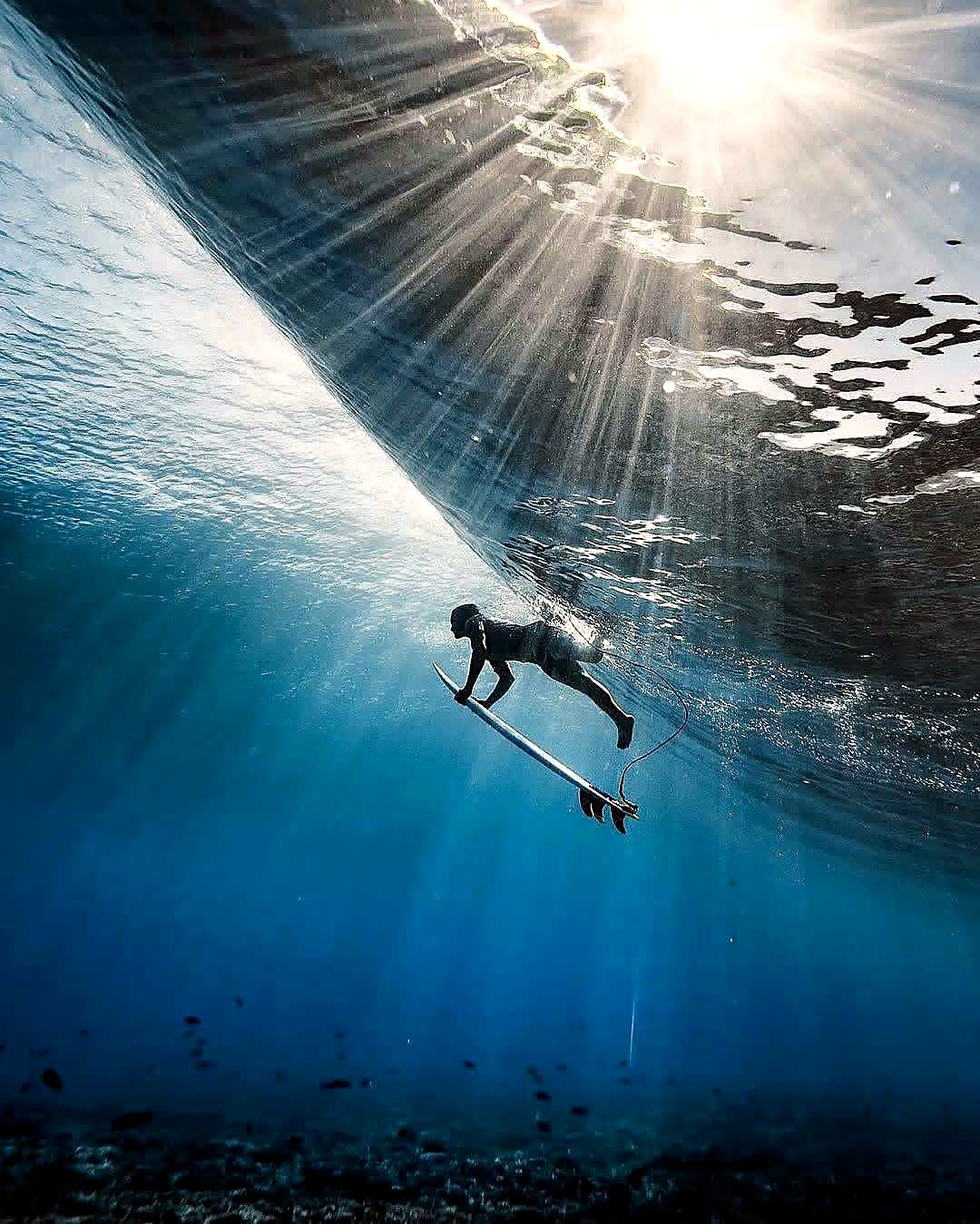 Underwater view of a surfer duck-diving a wave